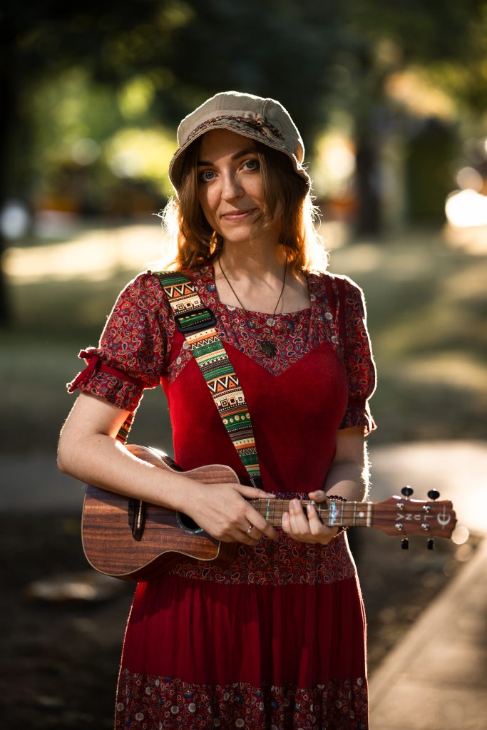Młoda kobieta z ukulele w dłoniach.